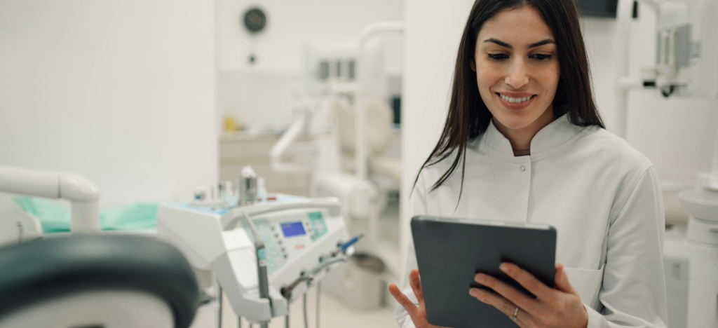 Dental software - A female dentist using a tablet device to check her practice’s billing workflow.