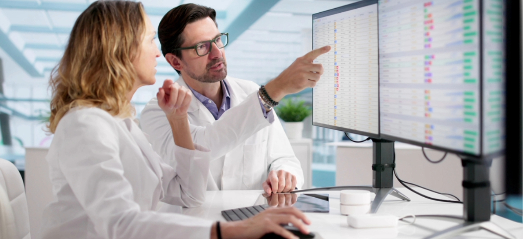 Revenue cycle vendors - Two medical professionals reviewing patient bills on separate computer screens.