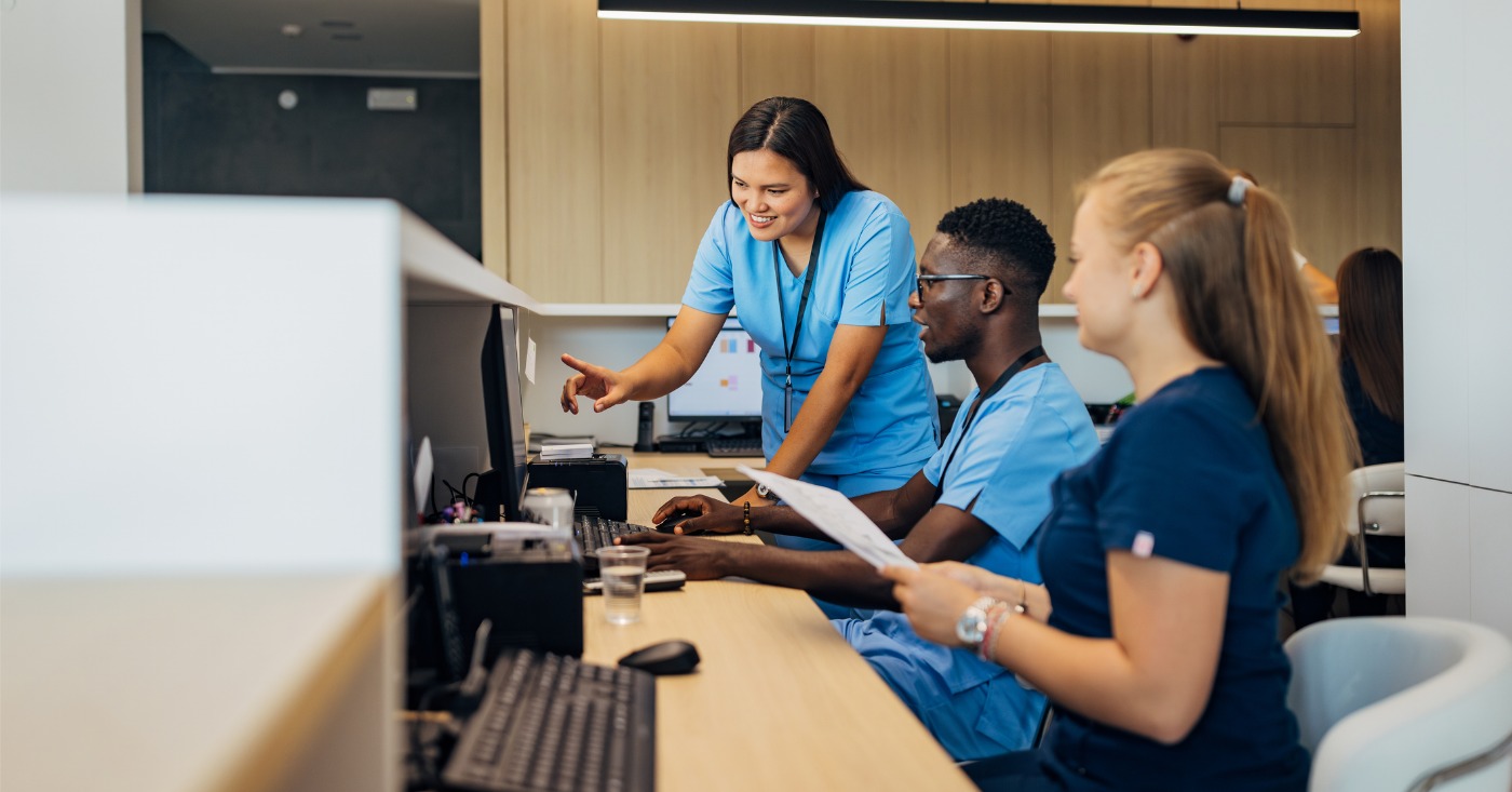 Improving staff productivity - A group of medical professionals using computers to check staff workflows and tasks.