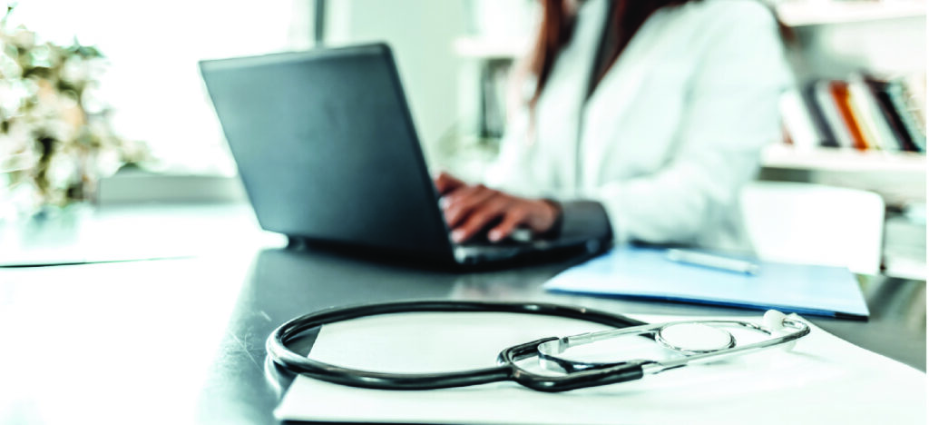 Using efficient software for medical billing - A female doctor in her office using a laptop.