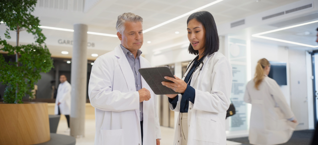 Two doctors using a tablet device to review their practice’s operations.
