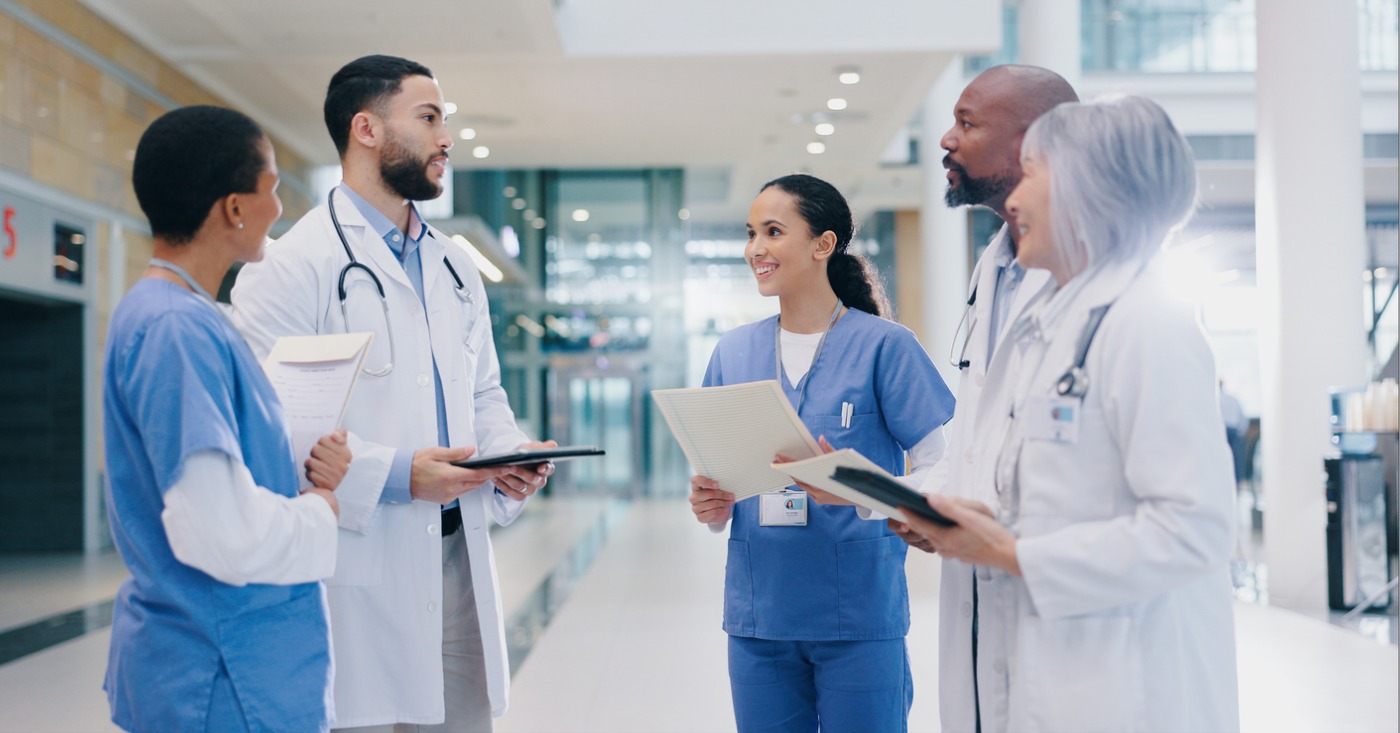 Pre-visit billing for healthcare practices - A team of healthcare professionals discussing operations in a hospital lobby.