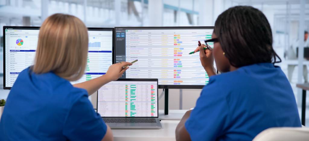 Payment Processing Ecosystem: Two medical billing staff go over billing codes.