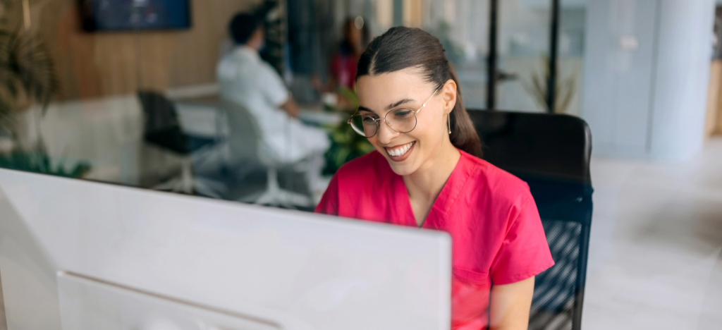 A female hospital staff member using a computer to check patient billing.