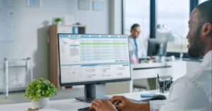 Revenue cycle vendors - A male doctor using a computer to access his practice’s billing software.