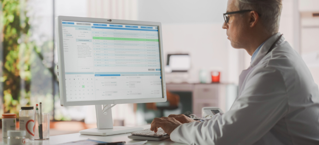 Upgrading your billing workflow process - A male doctor using a computer to access patient payment information.