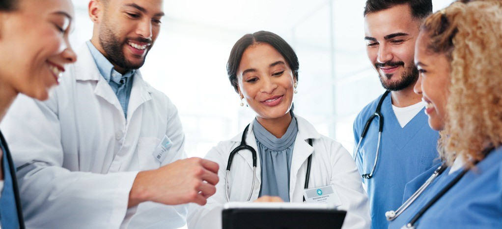 Improving staff productivity - A team of medical professionals looking at their workflow on a tablet device.