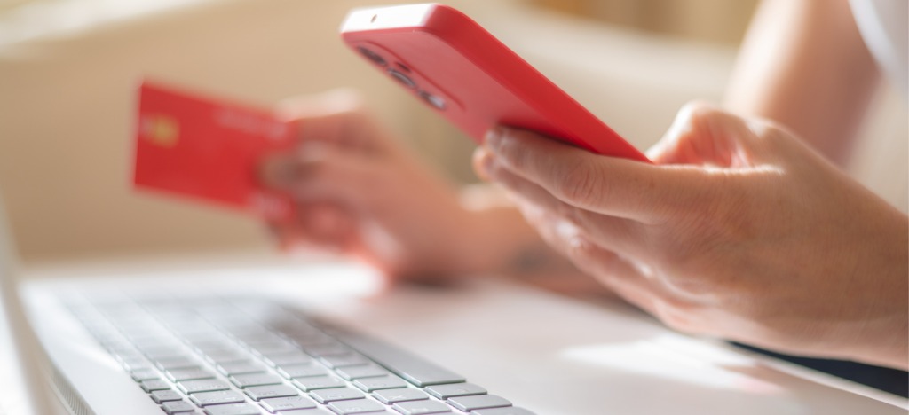 Increasing staff productivity - A person holding a credit card and using a smartphone to pay medical bills online.