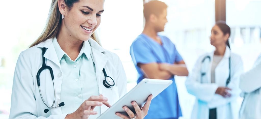 Rev cycle management - A female doctor using a tablet device to check her practice’s billing and collections software.