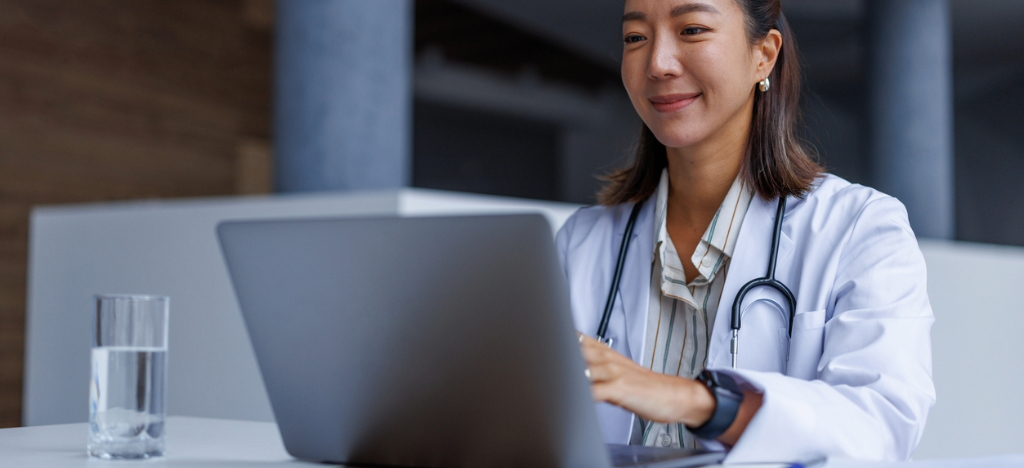 AI medical billing - A female doctor in a hospital using a laptop to check her practice’s payment solutions.
